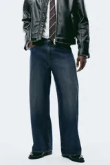 Jean de cinco bolsillos en denim de algodón rígido, color azul oscuro. Modelo de corte holgado de cadera a bajo con pierna amplia y tiro caído. Cintura estándar y cierre.