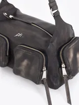 Cartera de hombro confeccionada en cuero vacuno color bordó con acabado desgastado. Presenta múltiples bolsillos exteriores con cierre en el frente, dorso y laterales, herrajes metálicos plateados y logo de la marca aplicado en el frente.