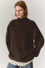 Buzo de corte holgado en punto suave con mezcla de mohair y lana, de color marrón oscuro, con cuello alto, hombros caídos y un bajo superpuesto de encaje en color crudo.
