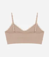 Soutien tipo top alargado color beige, confeccionado en tejido seamless de poliamida y elastano. Presenta breteles finos ajustables, relleno removible y un borde de encaje estrecho en el escote.