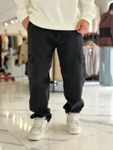 Pantalón cargo de jean azul con múltiples bolsillos en los laterales y diseño holgado.