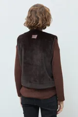 Chaleco reversible de corte recto, con un lado de cuero sintético color chocolate y el otro lado de piel sintética al tono. Presenta cuello redondo y diseño sin mangas.
