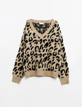 Buzo tejido de lana color beige con estampado animal print de leopardo en negro, escote en V y mangas largas. Marca Q2, talle Medium.