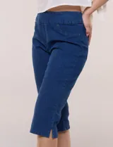 Capri de denim blanco con pretina ancha elastizada, tiro alto, bolsillos simulados al frente y bolsillos funcionales en la parte posterior, con pequeños tajos laterales en el bajo.