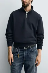 Sudadera roja de corte regular, con cuello alto y cierre frontal de cremallera. Manga larga y terminaciones en rib.