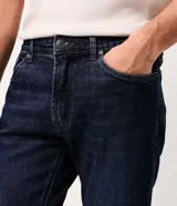 Pantalón de jean slim para hombre, de color azul clásico con lavado uniforme. Cuenta con cintura con pasadores, cierre con botón y cremallera, y bolsillos funcionales delanteros y traseros.