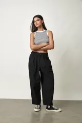 Pantalón negro de tiro alto y corte amplio, con pinzas en la cintura y bolsillos laterales.