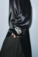 Blusa de Zara Woman Collection confeccionada en viscosa, con cuello alto, manga larga y diseño asimétrico en el bajo. Presenta un acabado satinado y cierre en la espalda.