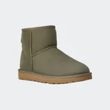 Botas de caña baja UGG, color negro, confeccionadas en piel de oveja con forro interior de lana suave y suela de goma resistente.