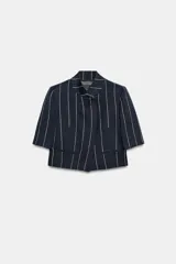 Chaqueta corta ZARA Woman Collection de diseño estructurado, color azul marino con patrón de rayas diplomáticas claras. Presenta cuello redondo mao, manga corta, falsos bolsillos de vivo en el delantero y cierre frontal cruzado con un botón.