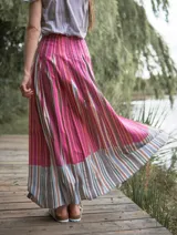Falda larga de lino con estampado a rayas verticales en tonos rosados, fucsias y marrones.