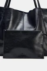 Bolso formato maxi shopper de piel con acabado brillante, detalle de pespuntes a tono y asas de hombro. Incluye una cartera extraíble con cierre y logo de la marca grabado.