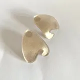 Par de aros dorados con forma irregular y diseño moderno.