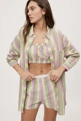 Camisa oversize de manga larga con estampado de rayas verticales en tonos rosado, celeste y verde menta. Cuenta con cuello camisero, cierre frontal con botones y un bolsillo aplicado en el pecho.