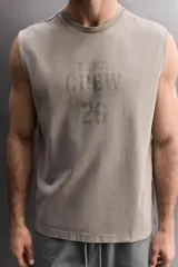 Musculosa de algodón con calce relajado y efecto lavado. Presenta cuello redondo, sisas amplias y estampado frontal con texto y logo a contraste.