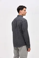 Camisa de corte regular fit confeccionada en algodón, con estampado de cuadros, cuello solapa clásico, cierre frontal con botones y dos bolsillos en el pecho.