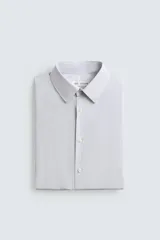 Camisa de corte regular fit confeccionada en tejido de algodón con diseño de rayas verticales finas. Presenta cuello italiano, manga larga con puños abotonados y cierre frontal mediante botonadura.