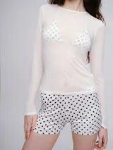 Mini short de lycra con estampado de lunares negros sobre fondo blanco, de corte ajustado y tiro medio.