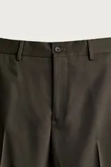 Pantalón de traje slim fit color marrón oscuro, confeccionado en tejido con viscosa, con bolsillos frontales, bolsillos traseros de doble vivo y raya marcada en las piernas.