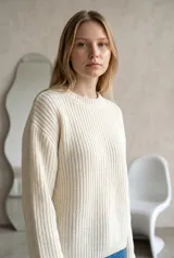 Sweater de punto en color tostado, con cuello redondo y mangas acampanadas estilo oxford. Presenta un tejido de textura acanalada y corte holgado.