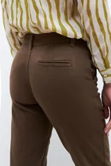 Pantalón chino color marrón con bolsillos laterales y traseros.