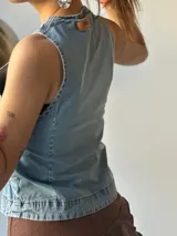 Chaleco de jean celeste con escote en V y lazos frontales.