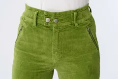 Pantalón de pana verde lima, tiro alto, corte skinny y pretina elastizada. Presenta bolsillos delanteros con cierre y dos botones en la cintura.