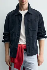 Sobrecamisa de corte relajado confeccionada en tejido de algodón con estructura canvas y efecto lavado. Presenta cuello solapa, cierre frontal con botones, mangas largas con puños abotonados y tres bolsillos frontales de plastrón.