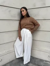 Sweater color crema tejido con diseño en ochos y cuello redondo.