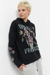 Canguro negro de algodón con capucha y mangas largas. Estampado frontal con flores y la inscripción "Wild Flowers".