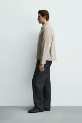 Sobrecamisa negra de corte relajado, confeccionada en tejido con mezcla de algodón elástico. Presenta cuello solapa, cierre frontal de cremallera, bolsillos de plastrón en el pecho y bolsillos de vivo en la cadera.