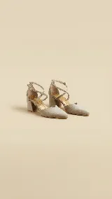 Zapato de tacón ancho de 5 cm, confeccionado en tela de tapicería color gris topo, con diseño de punta fina, escote en V y tiras cruzadas en diagonal con cierre de hebilla al tobillo.