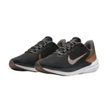 Championes de running Nike Air Winflo 9, color gris oscuro con detalles en cobre y plateado. Presentan diseño aerodinámico con logo lateral metalizado, entresuela blanca amortiguada y suela con relieve para mayor tracción.