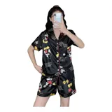 Pijama de dos piezas compuesto por una camisa de manga corta con botones frontales y un short, ambos con estampado animal print y detalles de vivo en contraste.