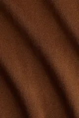 Polera de punto fino color marrón, con cuello alto, mangas largas y bajo recto. Cuello, puños y bajo acanalados.