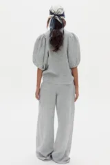 Pantalón de lino de corte ancho con diseño a rayas, tiro alto, bolsillos laterales y pinzas frontales.