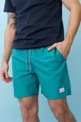 Bermuda de baño color verde agua con cintura elastizada y cordón ajustable. Bolsillos laterales y trasero con etiqueta de marca.