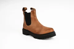 Bota tipo Chelsea de cuero color marrón, con paneles elásticos laterales en color negro, costuras a la vista y suela de goma dentada negra.