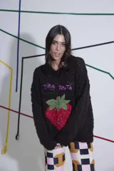 Sweater tejido de lana merino color negro, con cuello a la base y puños. Presenta un bordado artesanal de una frutilla en el frente.