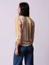 Blusa estampada de Zac & Rachel con cuello a la base, escote en V y botones. Tiene un bolsillo aplicado en la parte delantera, mangas largas regulables con presilla y botón, y terminación anudada opcional.