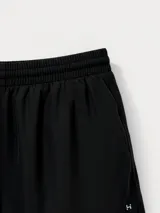 Short deportivo negro, de tela liviana y brillante, con cintura elástica fruncida y corte redondeado en el ruedo.