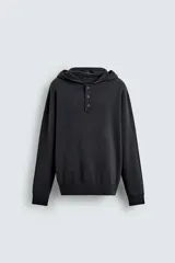 Jersey de punto de corte regular, confeccionado en una mezcla de algodón y lana. Presenta capucha, manga larga y cierre frontal con botonadura.