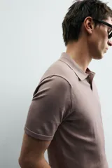 Polo de manga corta con cuello solapa y cierre frontal de botones. Confeccionado en tejido de punto con acabado en rib en puños y bajo.