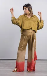 Pantalón palazzo color dorado con degradé rojo en el ruedo, tiro alto y lazo en la cintura.