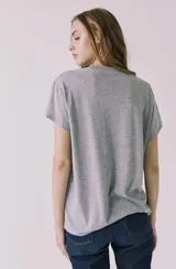 Remera gris melange de corte clásico y mangas cortas, con estampa frontal azul de Woodstock 1969 New York.