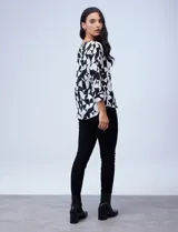 Blusa de gasa satén estampada con diseño animal print en tonos naranja y negro, de la marca Ninety. Tiene mangas tres cuartos y cuello redondo.