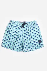 Short de baño celeste con estampado de hojas pequeñas en tonos verdes y blancos. Cuenta con cintura elástica con cordón ajustable, bolsillos laterales y un parche circular con logo en la parte inferior.