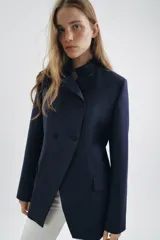 Blazer entallada de Zara Woman Collection, color azul marino, con cuello subido y detalle de tejido a contraste. Presenta cierre frontal cruzado con botones, manga larga y bolsillos con solapa en el delantero. Incluye forro interior.