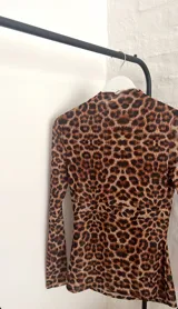 Top de microtul con estampado animal print de leopardo, doble tela, cuello alto y mangas largas.