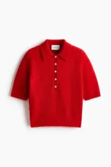 Remera polo de manga corta confeccionada en punto suave con mezcla de mohair y lana, color rojo, con cuello clásico, tapeta con botones frontales y ribetes acanalados.